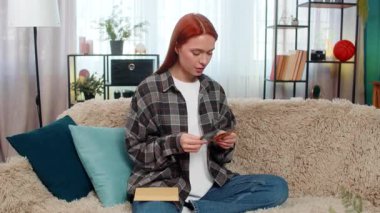 Evde avroyu sayan genç bir kadın ve tatmin olmuş bir gülümsemeyle zarfa bir parça koyuyor. Kafkasyalı kızıl saçlı kız kanepe planlama bütçesinde sorumlu ve duygusal olarak kendine güveniyor.