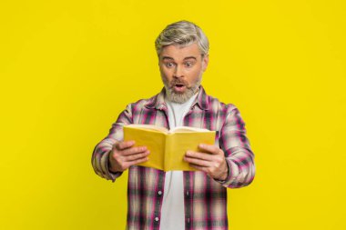 Olgun bir adam kitabı hevesli bir umutla açar, parlak bir sürpriz ve şaşkın bir heyecan gösterir. Sarı arka plandaki orta yaşlı adam şaşkınlığı gösteriyor. Vay canına. Sayfalarda gizli bir entrika olduğunu ima ediyor.