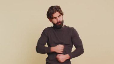 Uzun kollu Lübnanlı genç adam stres yüzünden bağırıyor. Sorunlar, çaresizlik, korku, panik şaşkınlığı, şaşkınlık jestleri, öfkeyi ifade ediyor. Hintli adam bej renkli stüdyoda izole edilmiş.