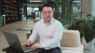 Dizüstü bilgisayarı olan olgun iş adamının portresi parmağını sıkar ve 