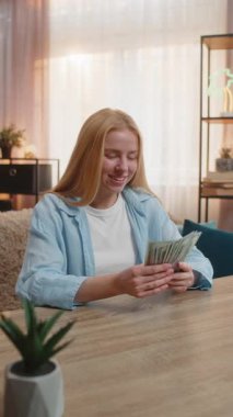 Genç bir kadın evde oturup elinde dolarla para sayıyor piyango zaferinden, maaşından, kazancından mutlu kahkahalar atıyor. Beyaz kız finansal sürprizi kutlayan banknotlar sallıyor. Gün batımı