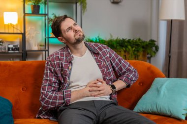 Kafkasyalı genç adam kanepeye oturur aniden karın ağrısı ve mide iltihabı hisseder. Sinir hastası, ishal, hazımsızlık, peptik ülser, pankreas hastası.