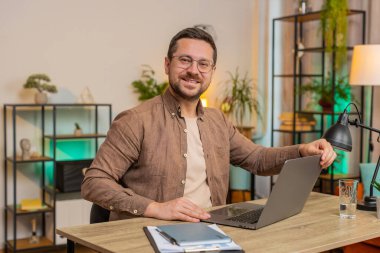 Kafkas genç iş adamı dizüstü bilgisayarı açıyor ve ofis masasında otururken proje üzerinde çalışıyor. Yetişkin adam internet üzerinde çalışıyor, mesajlar gönderiyor, online alışverişler yapıyor, film izliyor..