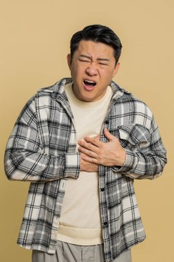 Stresli, orta yaşlı, Asyalı orta yaşlı bir adam kalp krizi geçirerek, kalp krizi geçirerek, kalp krizi geçirerek, kötü bir hastalık belirtisi göstererek gerilimden muzdarip..