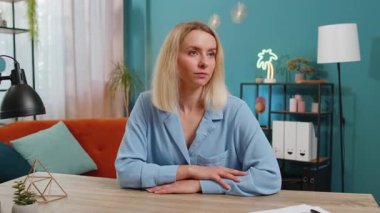 Ofis masasındaki gülümseyen sarışın beyaz iş kadını portresi yüzünü kameraya çevirmiş. Oturma odasında oturan serbest çalışan bir kadın var. Mavi elbiseli kız..