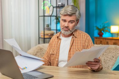 Beyaz, olgun bir adam evrak faturalarıyla çevrili masada oturuyor. Orta yaşlı bir adam mali zorluklar yüzünden hayal kırıklığına uğramış görünüyor. İflas sorunları çözmek için mücadele ediyor.