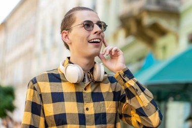 Beyaz erkek turist yaz günü açık havada şehir sokaklarında geziyor. Mutlu gülümseyen adam gömlekli gezgin pozitif bir ruh hali içinde eğleniyor, rüya görüyor, dinleniyor. Kasaba yaşam tarzları.