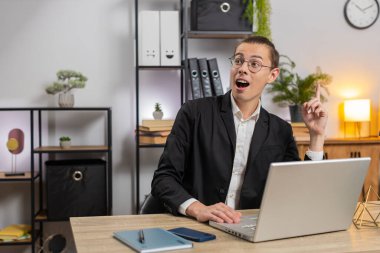 Gülümseyen beyaz bir adam dizüstü bilgisayarda iyi bir fikir bulmayı düşünüyor. Profesyonel iş adamı masadaki evden önemli e-postalar yazıyor. Çevrimiçi uzaktan kumanda işinde çalışan mutlu adam.