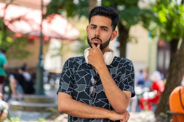 Düşünceli, düşünceli, düşünceli, düşünceli, genç Hintli bir adam. Düşünceli bir ifadeyle, bir çözüm düşünüyor, şüpheci bir soru soruyor, dışarıda hayaller kuruyor. Sakallı Hintli adam şehir caddesinde. Kasaba yaşam tarzları.