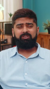 Akıllı telefon sohbeti sırasında tuhaf yorumları reddeden Hintli bir adam alaycı bir tepki gösteriyor. Kanepedeki Arap adam alaycılık gösteriyor. İnançsızlık hafif baş eğme sinir bozucu mizahi tavır sergiliyor..