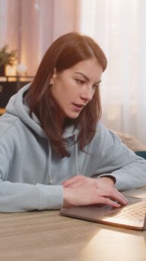 Serbest çalışan genç bir kadın dizüstü bilgisayarı kapatıyor ve neşeli bir şekilde iş gününün sonunda rahatlamaya hazır hale geliyor. Kafkasyalı kız dinleniyor. Masada oturuyor.