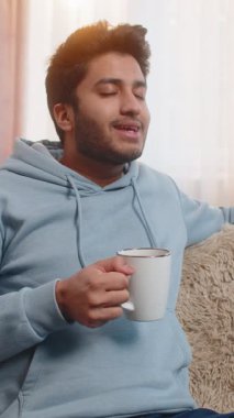 Gülümseyen Hintli adam evde sıcak kahve ya da bitki çayı içiyor. İspanyol adam moladan zevk alıyor, sabahları kanepede oturuyor, düşünceli bir şekilde uzaktan bakıyor ve dinleniyor..