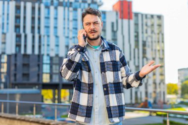 Şehir merkezindeki caddede dururken akıllı telefondan konuşan sinirli, olgun bir adam tartışır. Tatmin olmamış orta yaşlı bir turist telefona bağırıyor, tartışıyor, bir sorun var..