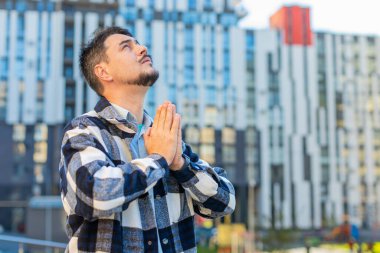 Şehir merkezindeki palmiyeleri katlayarak Tanrı 'dan yardım dileyen olgun, beyaz erkek turist suratı. Endişeli bir konsept. Binanın karşısında duran orta yaşlı bir adam sessiz mola vermeyi düşünüyor..