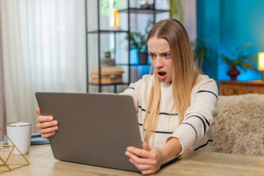 Masadaki beyaz kadın dizüstü bilgisayar, virüs hatası, kayıp veri, ekran, tıkırtı tuşları, endişeli, umutsuz, düzeltilmeye ihtiyacı var. Kafası karışmış, hayal kırıklığına uğramış, başını tutup yardım isteyen bir kız.