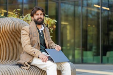 Hintli iş adamı serbest bilgisayar ekranını kapatıp internet üzerinden iş görüşmesi yapıyor. İnternet üzerinden sohbet ediyor, kameraya bakıyor. Sakallı adam not defteri kullanıyor, şehir merkezinde mesajlar yolluyor.