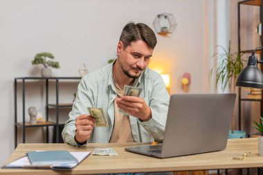 Planlama bütçesi. Zengin, mutlu bir adam, evdeki faturaları hesaplayarak para sayıyor. Beyaz adam gelir gelirinden memnun, planlı tatil hediyeleri için para. Yaşam biçimi.