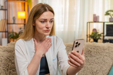 Orta yaşlı bir kadın evinde oturmuş akıllı telefondan üzücü mesajlar okuyor ve online oyun uygulamasını kaybediyor. Genç bir kız kötü haberleri ve kayıpları gözle görülür bir üzüntü ve duygusal durgunlukla karşılar.
