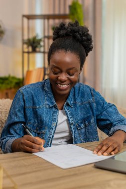 Afro-Amerikalı genç bir kadın ilk iş sözleşmesini ya da faturayı gururla imzalar. Siyahi kız önemli başarılarını kutluyor kariyerine özgüvenle başlıyor