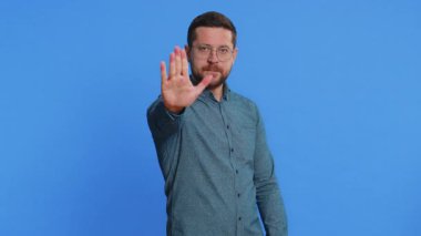 Dur, yeter. Orta yaşlı bir adam el ele tutuşmak yok diyor. Bitiş çizgisinde el ele tutuşmak yok. Bitiş uyarısı, erişime izin verilmemesi, iletişimin kopması, vücut dili tehlikesi. Mavi arka plandaki adam