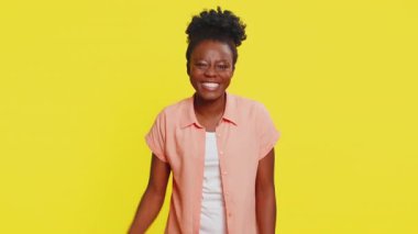 Mutlu Afro-Amerikalı kadın başarıyı kutluyor, piyango vurgunu hedefini kazanıyor iyi haber zaferini oynuyor. Sarı arka planda izole edilmiş genç siyah kız.