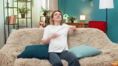 Evde orta yaşlı hamile bir kadın rahatlamaya çalışıyor ama gürültülü komşuların kanepeye vurduğunu duyuyor. Kanepedeki beyaz kız, ses stresinden kurtulmak için kulaklarını yastıkla örtüyor..