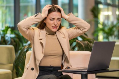 Kafkasyalı genç iş kadını dizüstü bilgisayarlı daktilo kullanıyor. Ani piyango sonuçlarını kaybediyor. Modern ofis lobisinde kötü haber kaybı. Otel odasında oturan bayan.