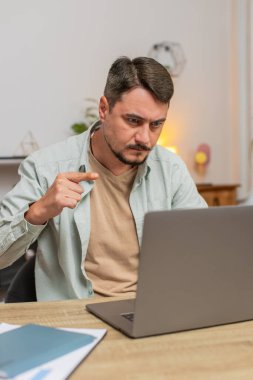 Ev ofisinin bilgisayarında çalışan serbest çalışan genç bir erkek çalışanla online iletişim videosu konuşması yapıyor, patron. Bilgisayar webcam 'ine bakan yönetici destek servisleri. Dikey.