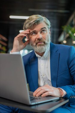 Modern ofis lobisinde dizüstü bilgisayarla çalışan sıkıcı, uykulu, olgun iş adamı. Yorgun, Kafkasyalı, serbest çalışan, takım elbiseli bir işkolik. İstihdam, meslek, işsiz.