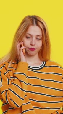 Zeki telefondaki sinir bozucu sıkıcı konuşmalarla ilgilenmeyen sarışın kadın. Kız, arkadaşıyla cep telefonu konuşmaktan yorgun düşmüş. Çevrimiçi konuşmayı sarı arka planda izole ediyor.