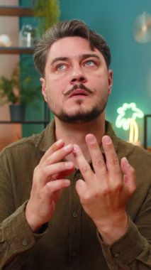 Evdeki orta yaşlı adam, ileriyi düşünerek parmaklarını sayıyor. Kanepedeki genç adam kararları değerlendirirken tereddüt ediyor. Önemli hedefleri değerlendiriyor. El numaralarıyla ilerlemeyi takip ediyor.