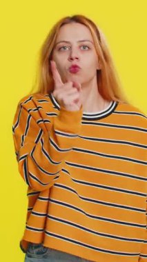 Tartışma. Rahatsız ve hoşnutsuzlukla el kol hareketi yapan, başarısızlıktan dolayı azarlayan, bunun neden olduğunu soran genç bir kadın. Esmer, çekici kız, sarı stüdyo arka planında izole edilmiş.