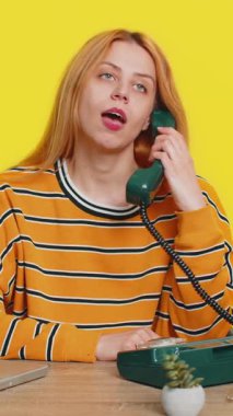 Merkezi ya da destek operatörü yardım hattını ara. Dizüstü bilgisayarda çalışan bir kadın 90 'ların telefon konuşmalarından kalma eski moda bir telefon kullanıyor. Sadece sarı arka planda izole genç bir kız.