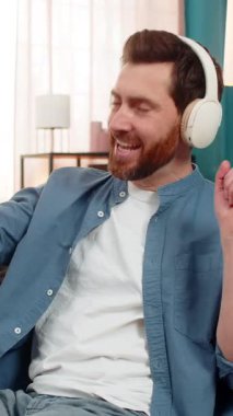 Evde kulaklıklı müzikten hoşlanan, ritmik dans eden ve elleri ritme göre hareket eden bir adam. Kanepede oturan beyaz adam ritmi hissediyor, sese dalmış, gevşemiş ve duygusal olarak meşgul.