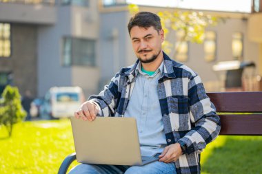 Kafkasyalı serbest çalışan, internette uzak bir işte çalışan, dizüstü bilgisayarlı, şehir sokaklarındaki internet sitelerinde takılan internet sohbetleri yapan bir adam. Netbook ekranı kullanan mutlu adam film izleyen mesajlar gönderiyor.