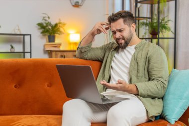 Evdeki koltukta oturan yorgun, kafkas bir adam dizüstü bilgisayar kullanıyor ve stresli. Şok olmuş esmer adam kaybına tepki veriyor, Netbook 'ta kötü haber oturma odasında. Bilgisayar virüsü.