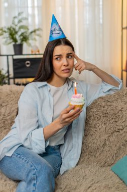 Evde yalnız genç bir kadın, ne yazık ki doğum gününü yalnız kutluyor elinde mumlarla pasta tutuyor. Kafkasyalı mutsuz kız koltukta duygusal olarak hayal kırıklığına uğramış, davetli yok, yalnız ve üzgün.