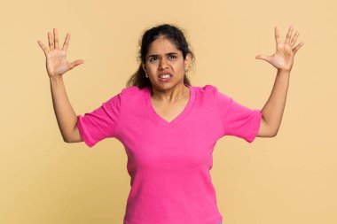 Hintli kadın dramatik bir şekilde el sallıyor, ağzı sonuna kadar açık, güçlü bir heyecan ya da panik gösteriyor. Arap kızı duygusal şoku, sürprizi, aciliyeti veya yoğun tepki anını ifade ediyor.