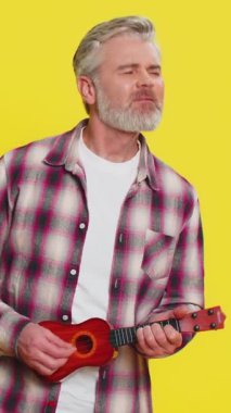 Olgun bir adam gitar çalıyor. Kafasını sallıyor ve gamsız bir mizahla gülüyor. Müziğin ritminden keyif alıyor. Orta yaşlı oyuncu sarı arka planda dans figürleriyle müzik sahnesini birleştiriyor.