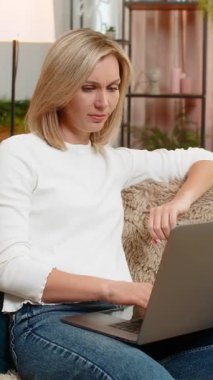 Orta yaşlı bir kadın dizüstü bilgisayarını kapatıyor ve kızgın bir şekilde elini sallayarak hayal kırıklığına uğruyor. Yetişkin kadın uzun ve stresli bir çalışma seansından sonra duygusal çöküntü ve tatminsizlik yaşıyor.