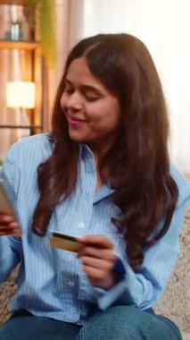 Hintli bir kadın pizza ve fast food siparişi vermek için akıllı telefon kullanıyor. Beklerken mutlu bir şekilde gülümsüyor. Arap kızı sevinçle doğum yapar, rahatlık, haz ve mutluluk verir.