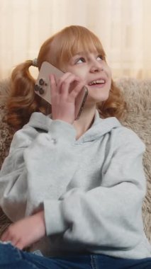 Genç bir kız evde telefonla annesini arıyor, hevesle konuşuyor ve hastasıyla başını sallayarak dinlemek için duruyor. Kanepede oturan sarışın çocuk günlük hikayelerini, dostça konuşmalarını ve kahkahalarını paylaşıyor.