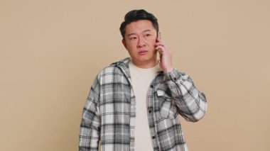 Asyalı ilgisiz bir adamın akıllı telefondan sıkıcı konuşmaları. Çinli adam arkadaşıyla cep telefonu konuşmaktan yorgun düşmüş. Bej arka planda çevrimiçi konuşma yapmış.