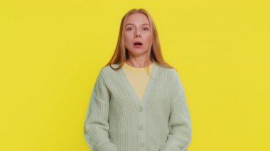 Şaşırmış, heyecanlı, orta yaşlı, beyaz, sarışın kadın kafasına dokunuyor ve kafa patlaması gösteriyor. Endişeli ve şok olmuş görünüyor, profesyonel olarak tükenmiş. Sarı arka planda izole edilmiş genç bir kız.