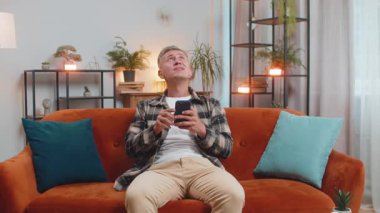 Komşularda tamirat. Sinirli beyaz adam, gürültülü müzik komşularının baş ağrısı sessizliğinden rahatsız olduğu yastıklarla kulaklarını kapatıyor. Evde ses yalıtımı olmayan ince duvarlar.