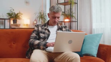 Gri saçlı hoşnutsuz bir adam dizüstü bilgisayarı kullanıyor daktilo yazarken kaybediyor. Aniden piyango şaşırıyor. Kötü haber kaybı..