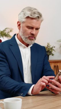 Merkez ofisteki orta yaşlı işadamı akıllı telefon okuma projesine bakıyor. Başarısızlık uyarısı derin umutsuzluk içinde nefes alıyor. Masadaki serbest çalışan adam üzüntülü bir şekilde iç çekiyor. Bir sonraki çalışma adımını planlarken yığılmış durumda..