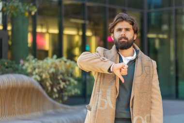 Hoşlanmamak. Sinirli Hintli adam işaret dilini gösteriyor, hoşnutsuzluğunu dile getiriyor, tatminsiz kötü iş, açık havada hata yapıyor. Şehir caddesinde duran hoşnutsuz İspanyol işadamı.