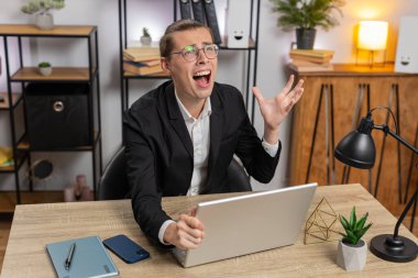 Genç, üzgün, stil sahibi bir iş adamı dizüstü bilgisayarda arama yapıyor, beklenmedik piyango sonuçlarını kaybediyor, servet kaybı, ofis masasında kötü haberler. Takım elbiseli, Kafkasyalı serbest çalışan.