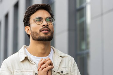 Kendine güvenen Hintli adam Tanrı 'ya gözleri kapalı dua ediyor dışarıda kutsama, yardım ve af diliyor. Şehir merkezindeki caddede el ele tutuşup şans dileyen Arap Hindu. İş adamları yaşam tarzları
